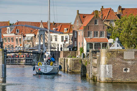 Enkhuizen, The Netherlands, September 13, 2019: motored modern sailing yacht approaching a pedestrian bridge in the old townのeditorial素材