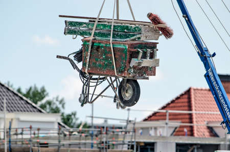 The Hague, The Netherlands, June 13, 2020: wheelbarrow with tools and equipment on a building site, suspended from a crane to prevent theftのeditorial素材
