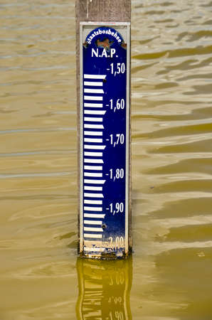 Pole with water level marker in a Dutch canal indicating the water is two metres below sea levelのeditorial素材