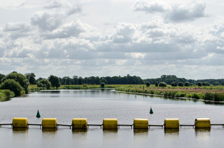 Yellow steel cylinders as a barrier in the river Vecht near Zwolle, The Netherlands to keep boats...
