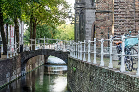 Delft, The Netherlands, August 23, 2020: the narrowest section of Oude Delft canal next to the tower of the Old Churchのeditorial素材