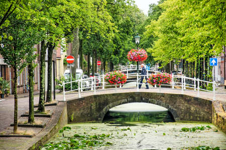 Delft, The Netherlands, July 20, 2020: picturesque view of Molslaan canal in the old town, with waterlilies, flowers and treesのeditorial素材