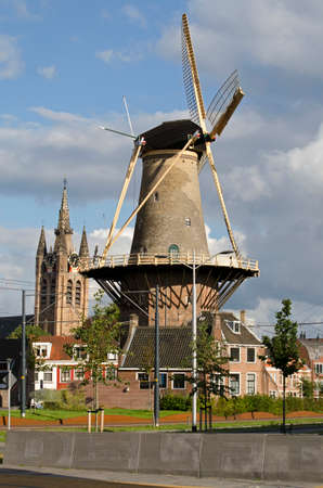 Delft, The Netherlands, August 23, 2020: view of reconstructed Phoenixstraat at the perimeter of the old town with windmill De Roos and the Old Churchのeditorial素材