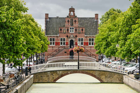 Oud-Beijerland, The Netherlands, July 10, 2020: the picturesque town hall on the axis of the tree-lined Voostraat canalのeditorial素材