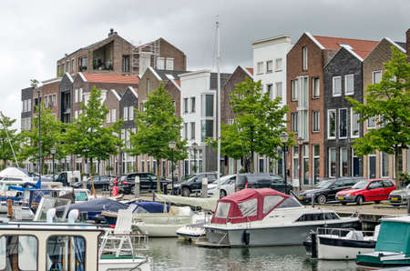 Oud-Beijerland, The Netherlands, July 10, 2020: marina with small yachts and a row of recent houses inspired by traditional architectureのeditorial素材