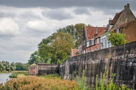 Woudrichem, The Netherlands, September 23, 2020: houses built on the town's wall, overlooking the surrounding nature and the river Waalのeditorial素材