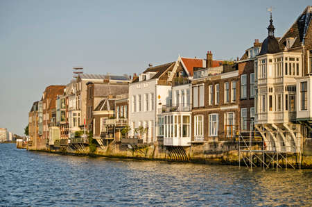 Dordrecht, The Netherlands, September 19, 2020: houses with cantilevered bay windows and balconies built on the bank of the river Oude Maas during the golden hourのeditorial素材