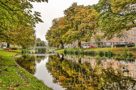 Rotterdam, The Netherlands, November 5, 2019: autumn scene at the green banks of Bergsingel canal with colorful trees reflecting in smooth waterのeditorial素材