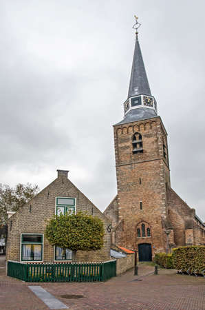 Zuidland, The Netherlands, September 30, 2020: view from Breedstraat (Broad Street) towards the Village church with its leaning tower under a cloudy skyのeditorial素材