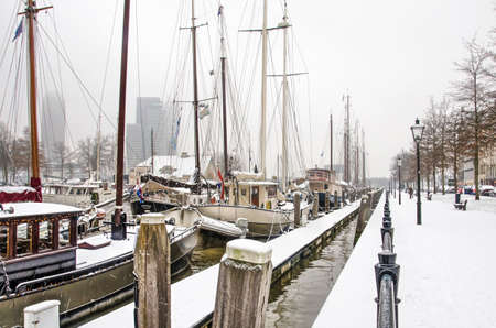 Rotterdam, The Netherlands, January 22, 2019: historic vessels in Veerhaven marina on a cold day in winter with the modern southbank highrise in the backgroundのeditorial素材