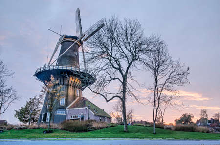 Leiden, The Netherlands, November 14, 2020: historic windmill De Valk on the city's ramparts park against a dramatic sky at sunsetのeditorial素材