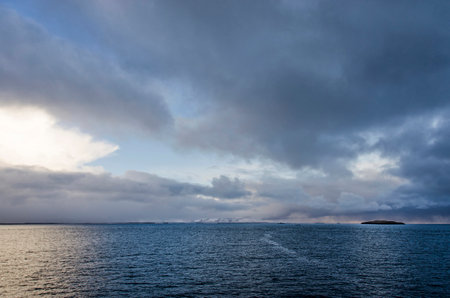 View from the deck of a ferryboat across BreiÃ°afjÃ¶rÃ°ur in Iceland under a sky with spectacular cloudsの写真素材