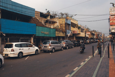 Suryakencana St, 30 june 2019, A man standing waiting for passing the street, Bogor, West Java Province, Indonesiaのeditorial素材