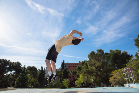 young male athlete doing parkour jumps and acrobatic exercises in the urban area of ââââa city category urban gymnasticsの写真素材