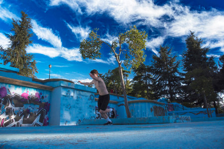 young male athlete doing parkour jumps and acrobatic exercises in the urban area of ââââa city category urban gymnasticsの写真素材