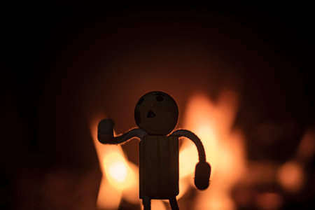 wooden figure between flames of fire with logs of firewood inside a fireplace autumn photos romantic photos of fireの写真素材