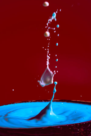 collision of moving water drops of blue color on a purple red background forming figures and waves when falling and colliding with each other photography and high resolution images relaxation photographyの写真素材
