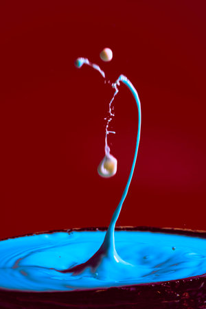 collision of moving water drops of blue color on a purple red background forming figures and waves when falling and colliding with each other photography and high resolution images relaxation photographyの写真素材
