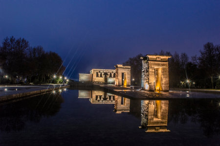 sunset view at the temple of debod in the city of madrid with reflections in the water urban...