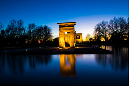 sunset view at the temple of debod in the city of madrid with reflections in the water urban...