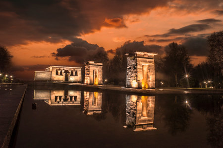 sunset view at the temple of debod in the city of madrid with reflections in the water urban...