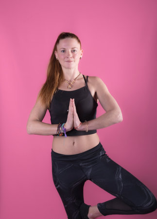woman with long blond hair performing a yoga posture moving her hands image with purple background photography happinessの写真素材