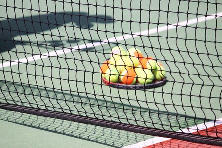 tennis court net with silhouette of a playerの写真素材