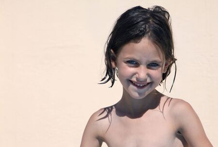 portrait of a young happy girl with blue eyes, wet hair looking at the cameraの写真素材