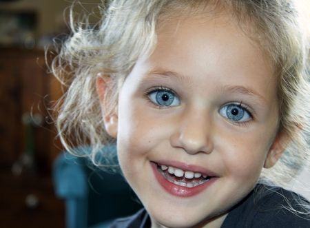 a happy smiling child portrait with blond hair and blue eyes