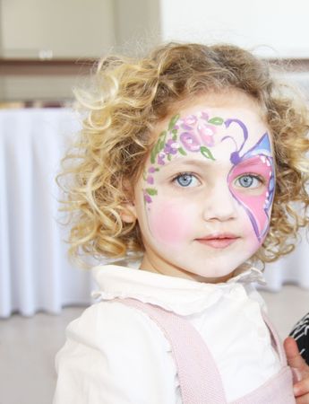 portrait of a caucasian child with her face painted with a butterflyの写真素材