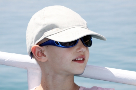 child with cancer wearing a cap and sunglassesの写真素材