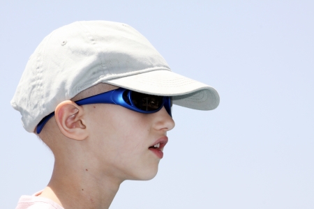 child with cancer wearing a cap and sunglasses の写真素材