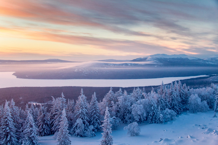 Landscape with cold and warm colors with mountains, forest and snowfieldの写真素材