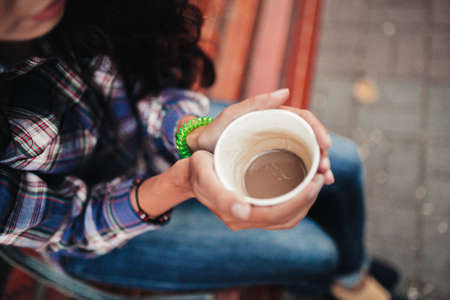 Closeup on a woman's hands holding a cup of tea
