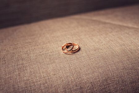 Gold wedding rings on a brown fabric