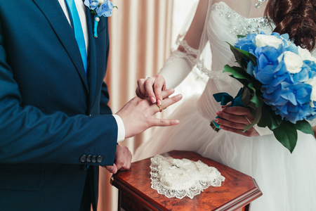 Bride putting on the groom's finger ringの写真素材