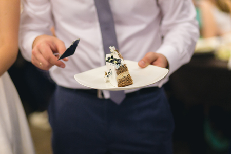 Newlyweds cutting delicious unusual wedding cakeの写真素材