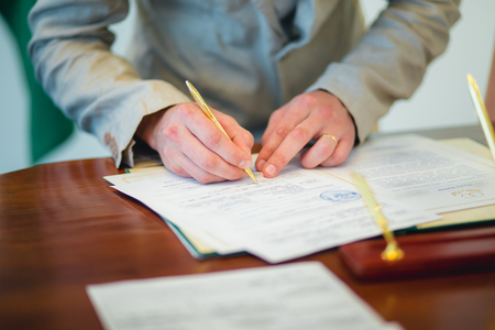 Groom signing marriage license or wedding contract