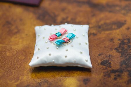 Gold wedding rings on a white pillowの写真素材