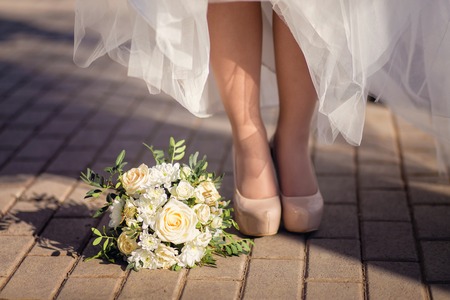 Bridal shoes and bouquet on the grassの写真素材