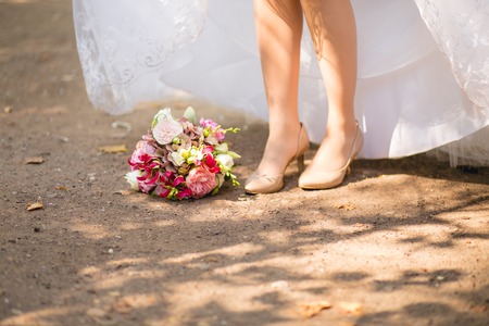 Bridal shoes and bouquet on the grassの写真素材