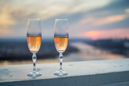 Glasses of champagne on a background of pale pink sunset skyの写真素材