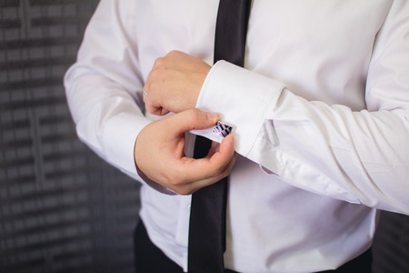 Elegant man\'s hand adjusting the cufflink