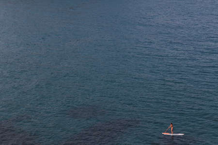 Woman is practicing Paddle Surf in Cabo de Gata