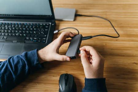 Man working from home on a laptop computer sitting at a desk surfing the internetの写真素材