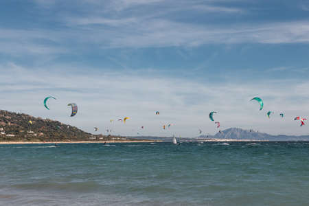 People are practicing kitesurf in the sea. They are ridging waves.の写真素材