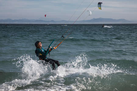 Teenager is practicing kitesurf. She is trying to control the kite.の写真素材