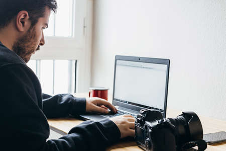 man is working editing photos with his equipmentの写真素材
