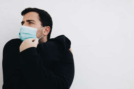 Man is stretching his arms before he exercises with a medical maskの写真素材