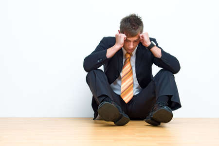 Unhappy businessman sitting on floorの写真素材